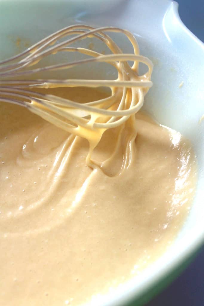 vegan cake batter dripping off a whisk